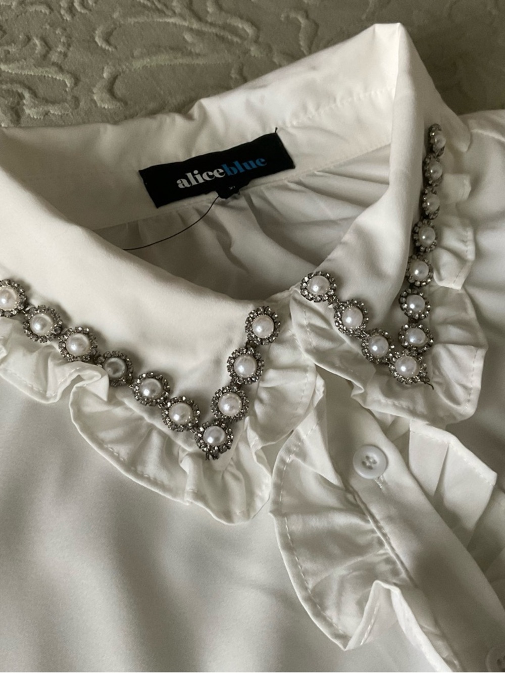 Beautiful collared white blouse, with simple pearls/rhinestones,